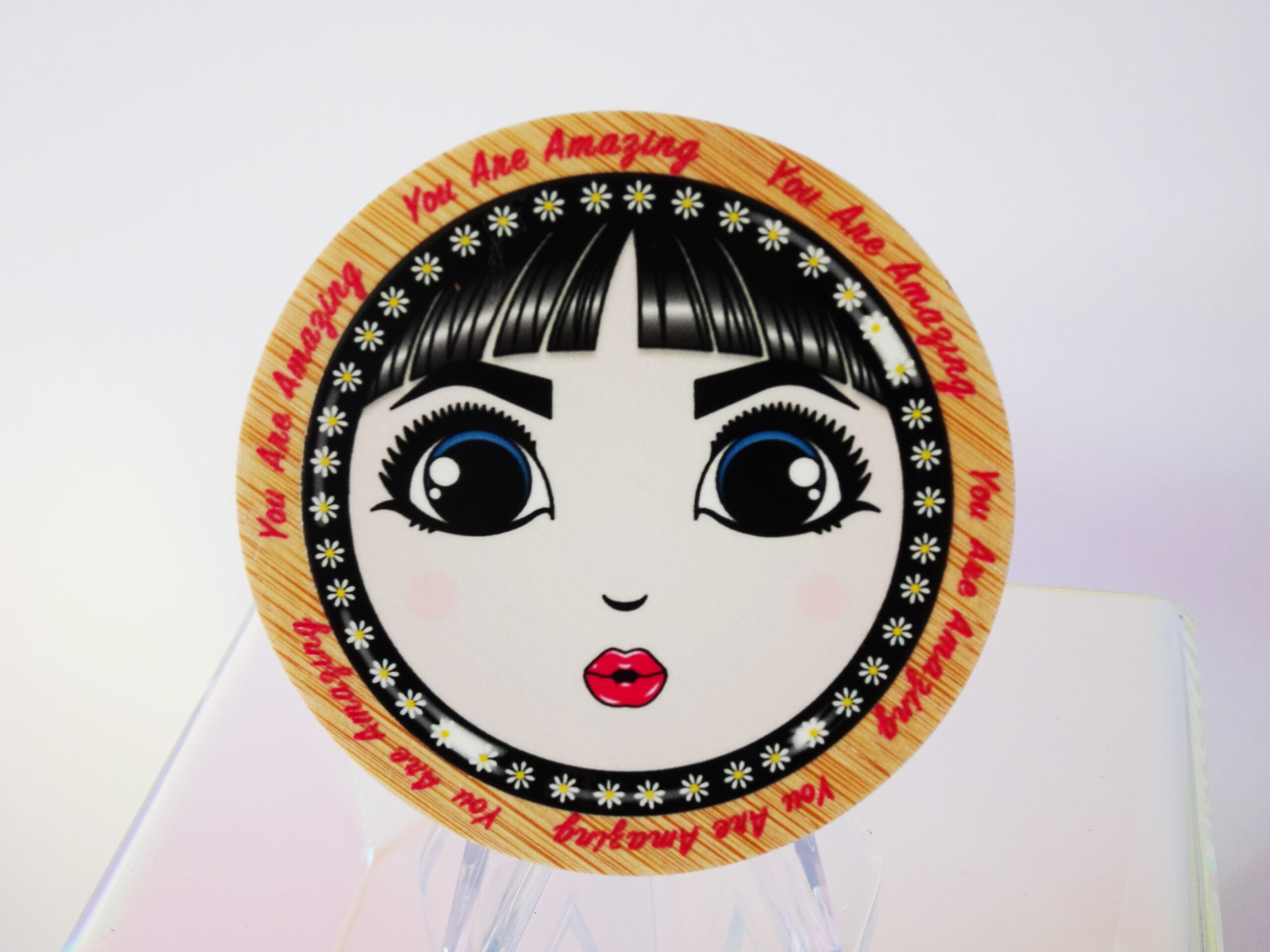 “You Are Amazing” bamboo pocket mirror featuring O’s face and retro lettering around the frame.